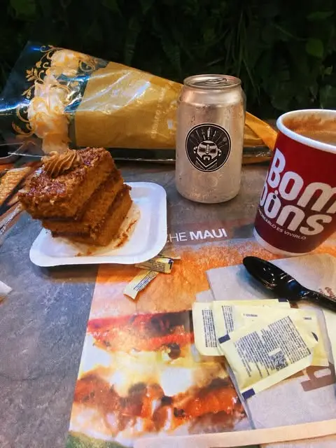 Lata plateada de VRIXZ en una mesa con pastel y café